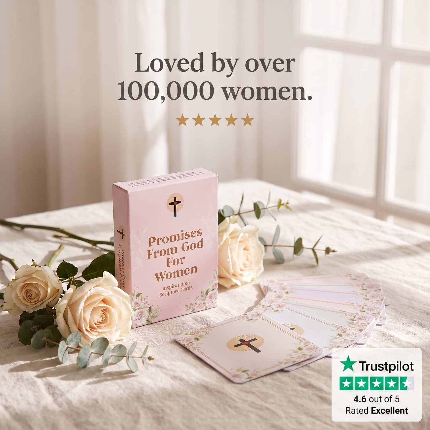 A pink card deck box labeled 'Promises From God For Women' sits on a bed with cream roses and greenery. A fanned-out set of cards is placed in front, with text above reading 'Loved by over 100,000 women.